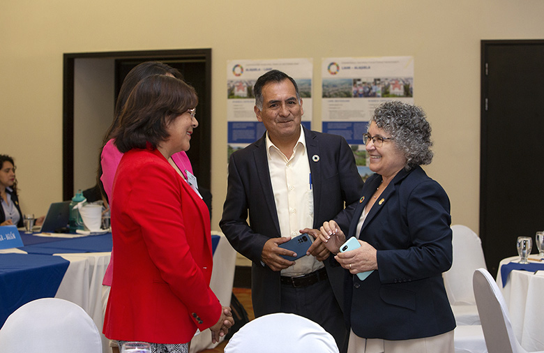 Teilnehmende aus Peru und Costa Rica sind lachend miteinander in ein Gespräch vertieft.